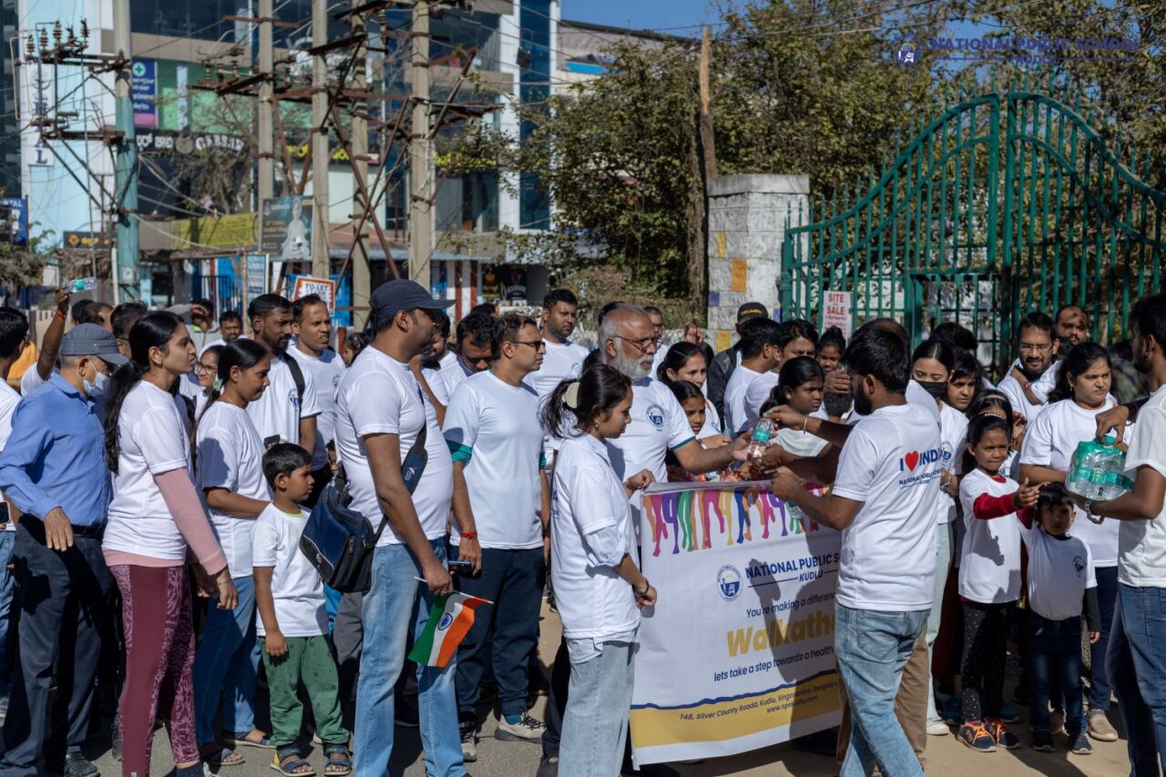 water bottles and refreshments are distributed to the crowd while they were marching towards the NPS kudlu campus on the Walkathon event which was organised for Republic Day by National Public School Kudlu.