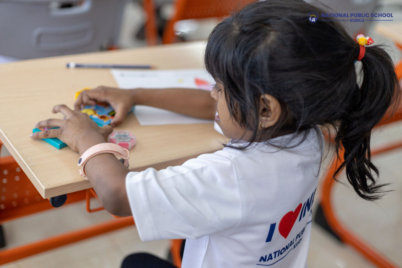 Kid arranging the crayon pencils after finishing the coloring to her drawing during the Walakthon Event at National Public School Kudlu